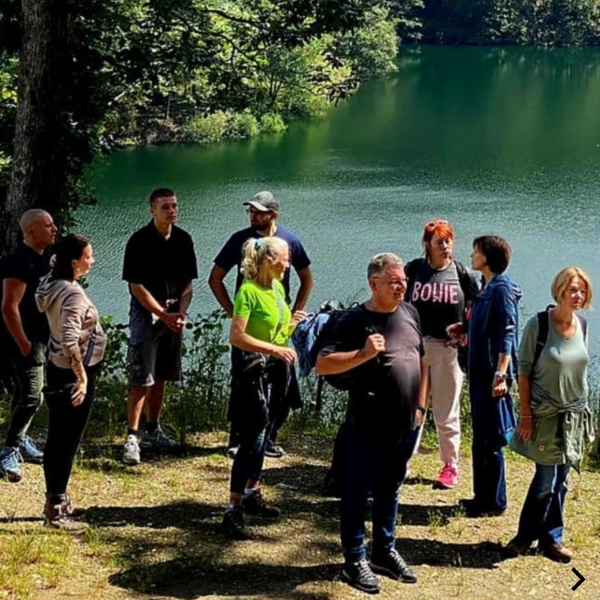 Eine Gruppe Menschen steht an einem See